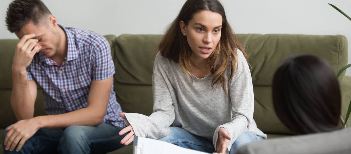 Frustrated stressed wife talks to psychologist about bad relationships sitting on couch with husband, unhappy woman sharing problems with counselor, couple counseling, family marriage therapy session